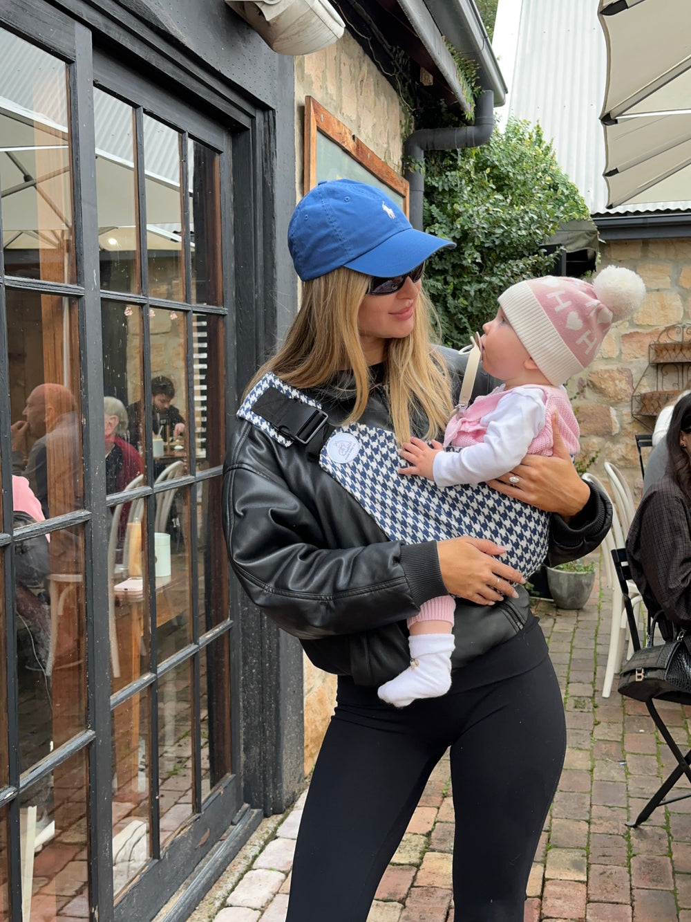 Harbour | Woman holding a baby outdoors with a reflective surface below