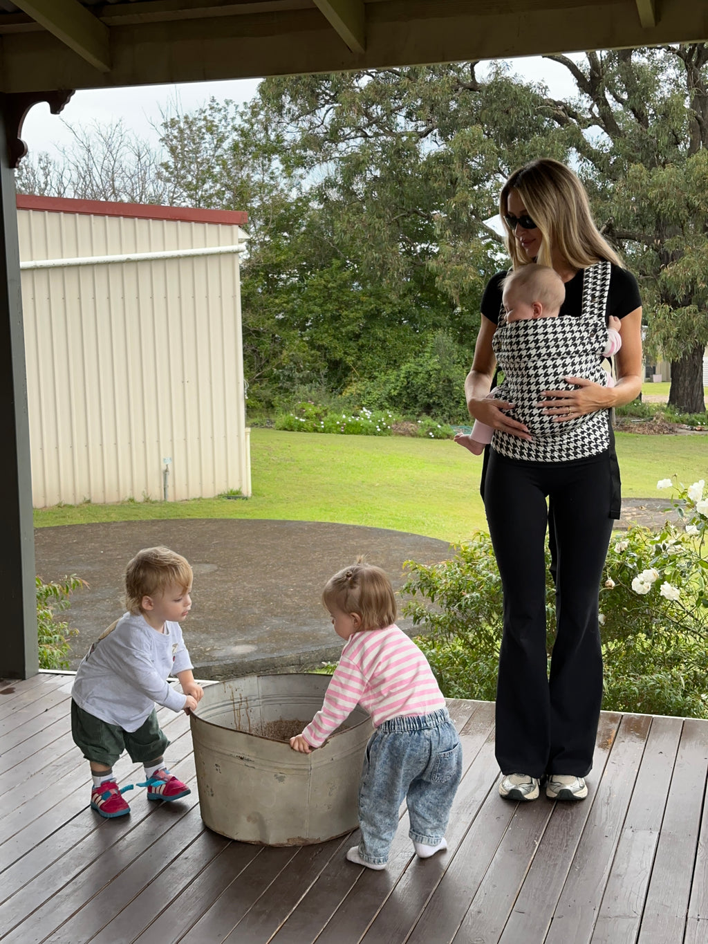 Salt & Pepper | Mum carrying baby in Haven Baby Carrier outside with toddlers and flowers